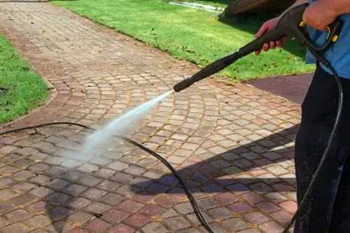 Het trottoir wordt gereinigd met een hogedrukreiniger